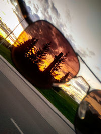 Reflection of sky on side-view mirror at sunset