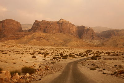 Scenic view of empty road in dessert against sky