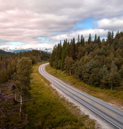 Road amidst trees against sky