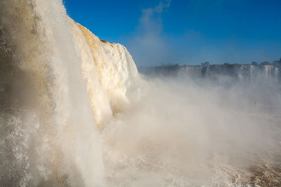 Scenic view of waterfall against sky