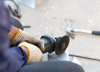 Man worker use handle fiber cutting to cut metal rail electric line in factory.