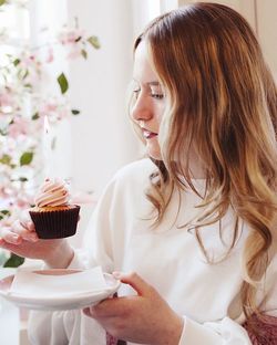 Portrait of young woman with cupcake