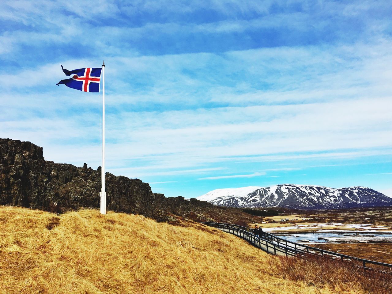 sky, flag, cloud - sky, patriotism, cloud, national flag, identity, pole, tranquility, cloudy, day, nature, tranquil scene, low angle view, red, landscape, wind, blue, outdoors, american flag