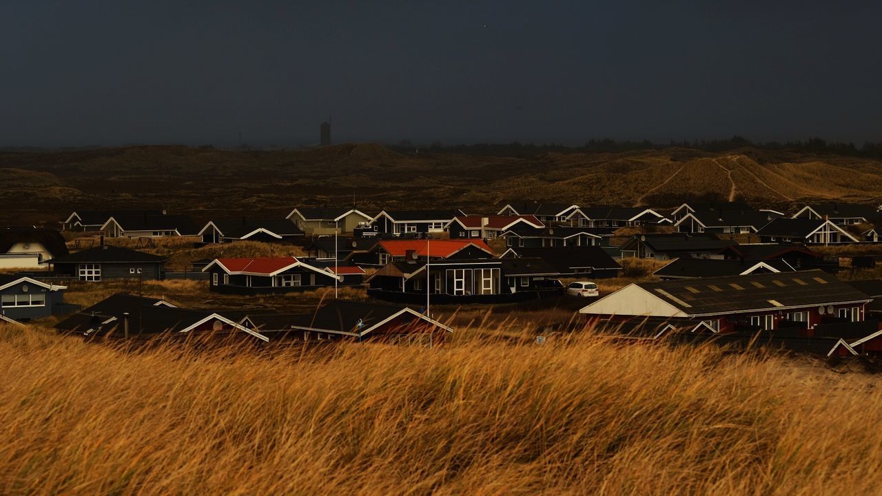 HOUSES AND FIELD AGAINST SKY AT NIGHT