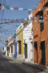 Houses by road in town against sky