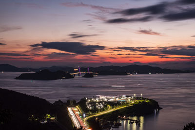 High angle view of the illuminated city against sky during sunset