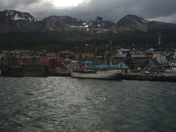 Boats moored at harbor against sky