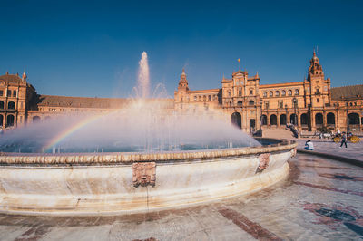 Fountain in city against sky