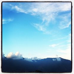 Scenic view of mountains against cloudy sky