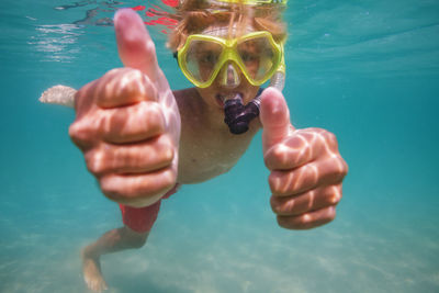 Cropped hand of man swimming in sea