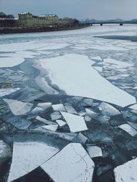 View of frozen river with building in background