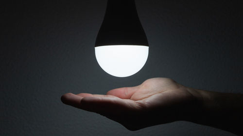 Close-up of hand holding light bulb