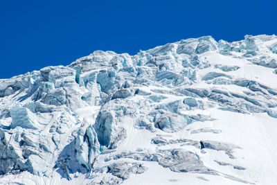 Scenic view of snow mountains against clear blue sky