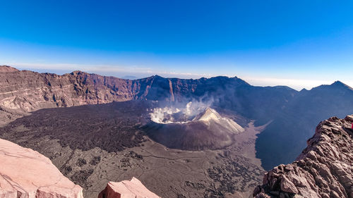 Panoramic view of rocky mountains against blue sky