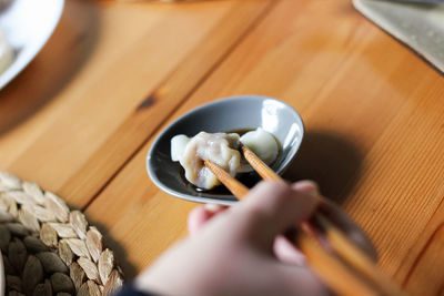 Woman eating dumplings with chopsticks in moganshan - china