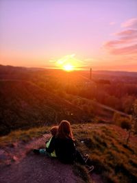 Rear view of woman looking at sunset