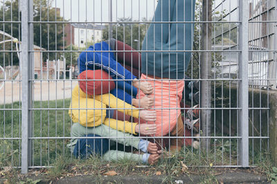 Shot of four children exercising by fences