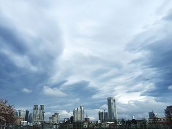 View of cityscape against cloudy sky