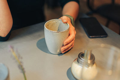 Midsection of coffee cup on table