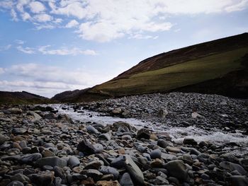 Surface level of rocks on shore against sky