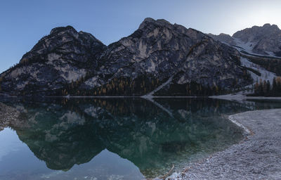 Scenic view of lake by snowcapped mountains against sky