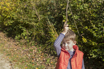 Portrait of boy standing against plants