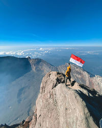 High angle view of woman holding flag on mountain