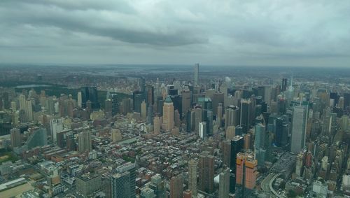 Aerial view of cityscape against cloudy sky