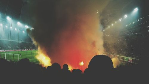 Crowd at music concert against sky at night