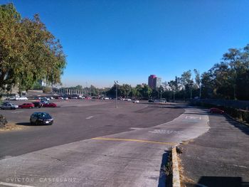 View of city street against clear blue sky