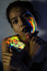 Close-up of woman with glowing paint on face