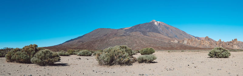 Scenic view of desert against clear blue sky