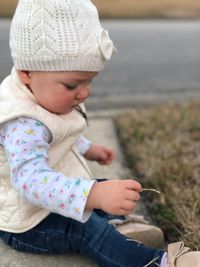 Close-up of baby girl sitting on sea shore