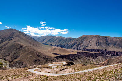 Scenic view of mountains against blue sky