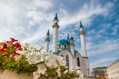 Low angle view of white building against cloudy sky