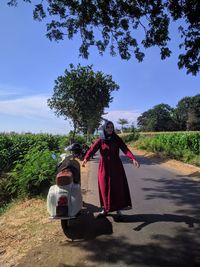 Rear view of man and woman on road against sky