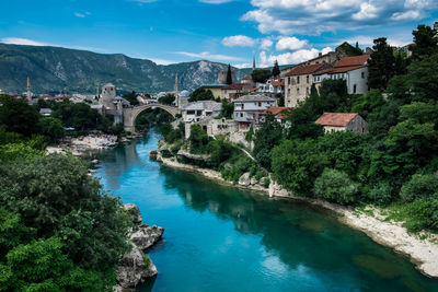 Bridge over river amidst buildings against sky