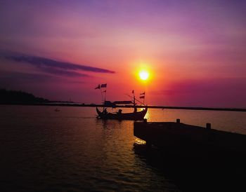 Silhouette boat in sea against sky during sunset