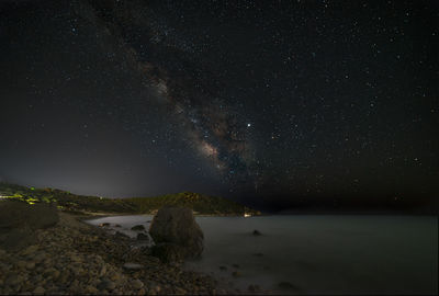 Scenic view of sea against star field at night