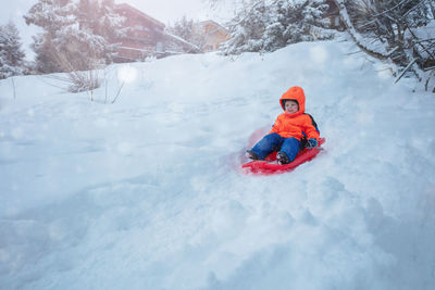 Rear view of man skiing on snow covered landscape