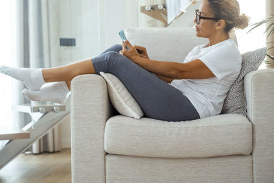 Young woman sitting on sofa at home