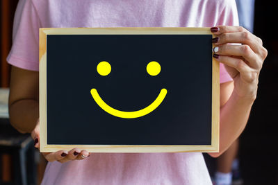 Close-up of woman holding yellow camera