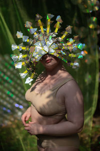 Portrait a woman in a reflective mask in a beige bikini on a cd / dvd case of scenery in the forest