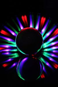 Close-up of illuminated colorful light bulb against black background