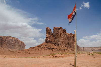 Low angle view of flag on desert against sky