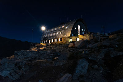 Illuminated abandoned building against sky at night