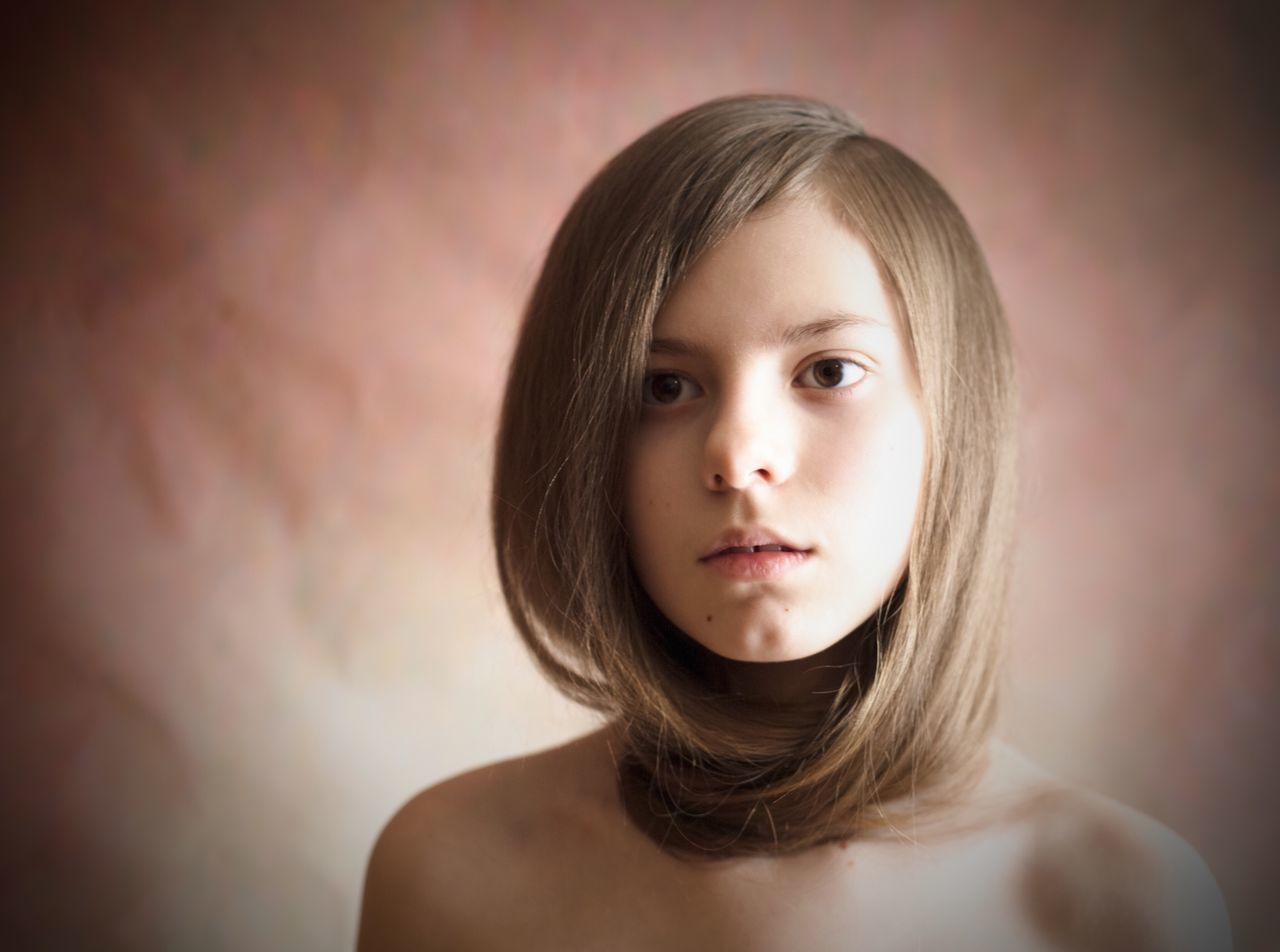 portrait, looking at camera, young adult, headshot, young women, person, indoors, lifestyles, front view, long hair, close-up, human face, leisure activity, head and shoulders, contemplation, wall - building feature