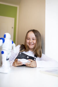 Portrait of smiling girl holding table