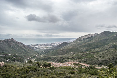 Scenic view of mountains against cloudy sky