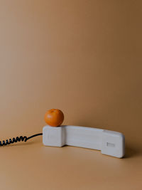 Close-up of fruit on telephone on colored background